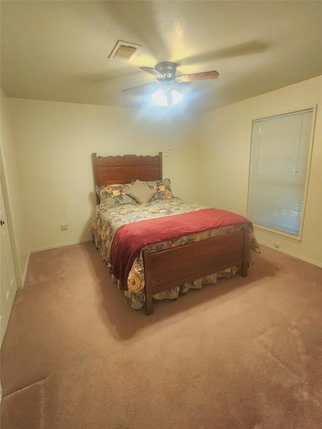 carpeted bedroom with visible vents, baseboards, and ceiling fan