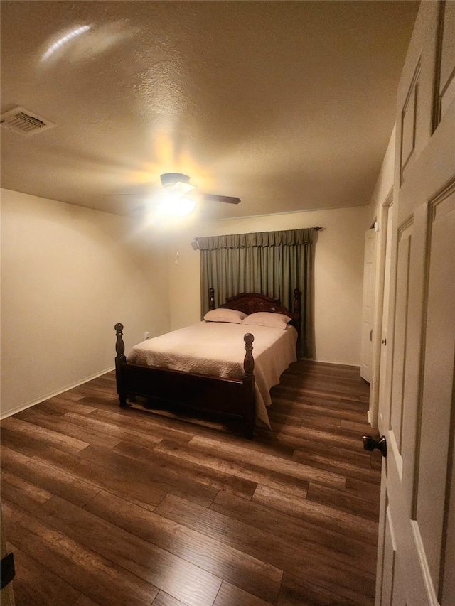 bedroom with visible vents, dark wood-style flooring, and ceiling fan