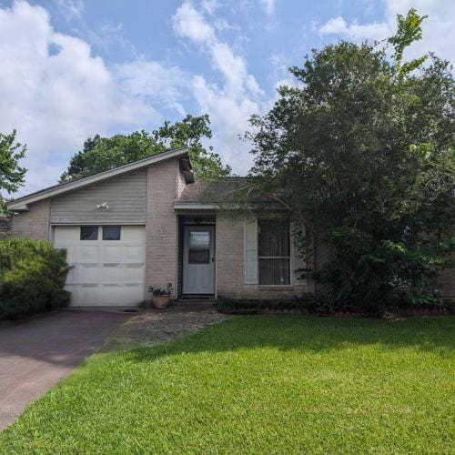 view of front facade featuring brick siding, a garage, a front lawn, and concrete driveway