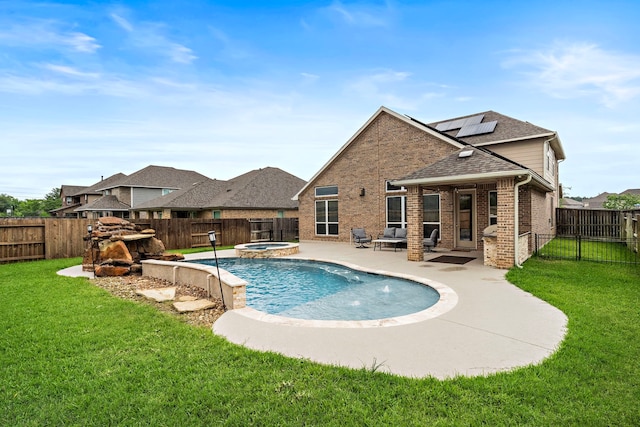 view of pool featuring a lawn, a patio, a pool with connected hot tub, and a fenced backyard