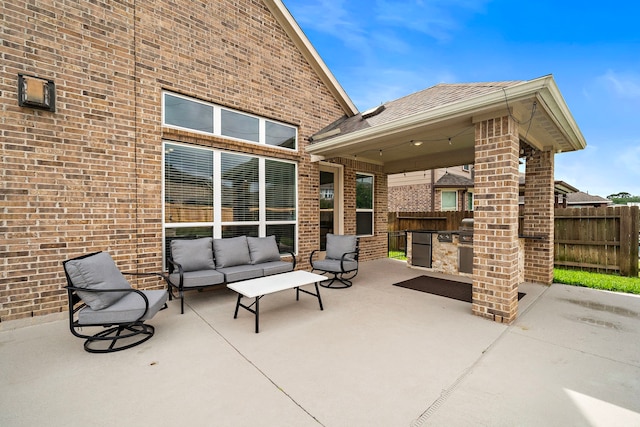 view of patio / terrace featuring fence, exterior kitchen, and outdoor lounge area