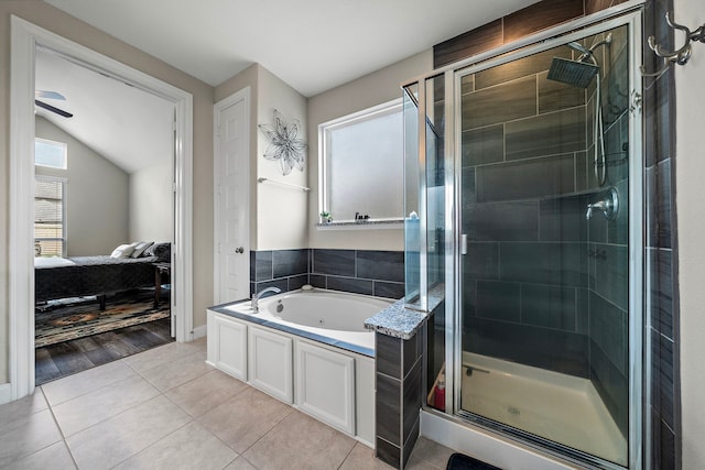 bathroom featuring a jetted tub, a stall shower, tile patterned floors, lofted ceiling, and ensuite bath