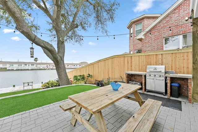 10 Quintana Pl, Galveston, TX 77554 - view of patio with a water view, a grill, fence, and outdoor dining space