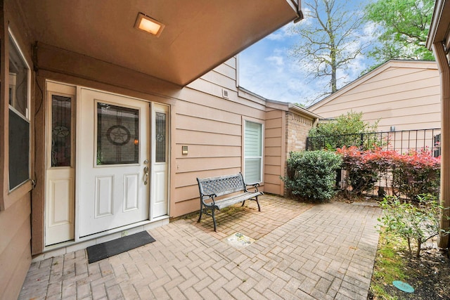 entrance to property featuring a patio area and fence