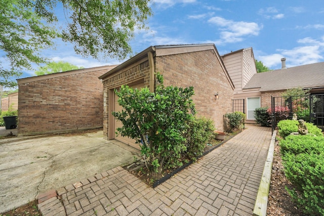 exterior space with an attached garage, driveway, and brick siding