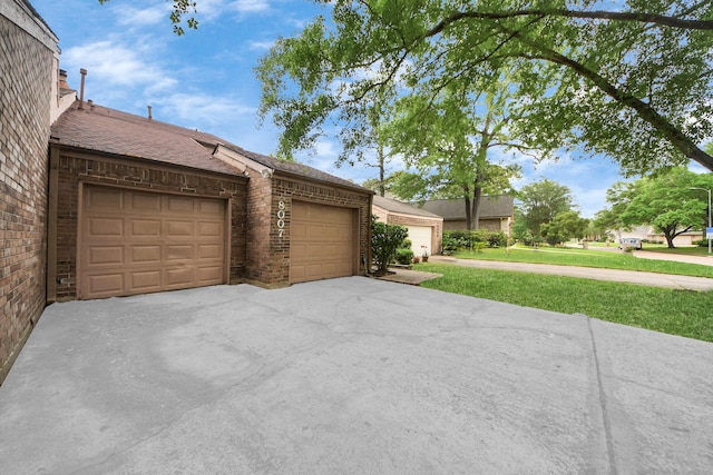 exterior space with a garage, a shingled roof, a front lawn, and brick siding