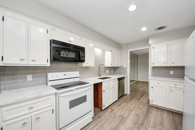 kitchen with visible vents, white appliances, white cabinetry, a sink, and light wood-style flooring