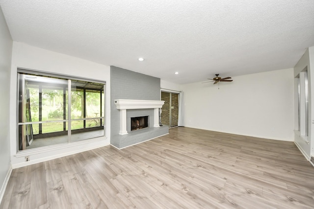unfurnished living room with wood finished floors, a fireplace, ceiling fan, recessed lighting, and a textured ceiling