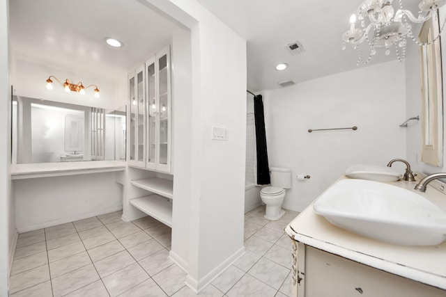 bathroom with double vanity, toilet, a sink, and tile patterned flooring