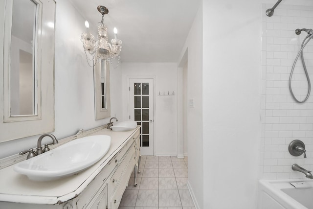bathroom with an inviting chandelier, a sink, tile patterned flooring, and double vanity