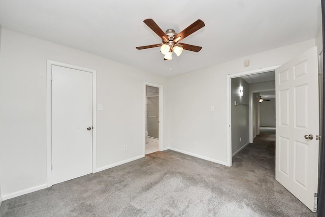 unfurnished bedroom with carpet flooring, a ceiling fan, baseboards, and connected bathroom