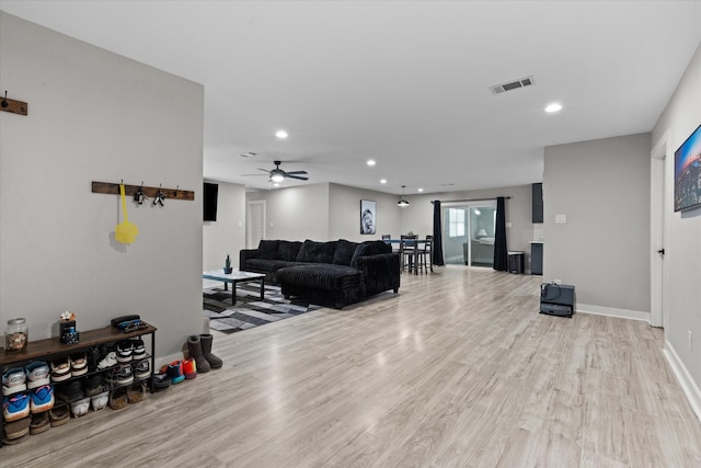 living area with wood finished floors, recessed lighting, ceiling fan, and baseboards