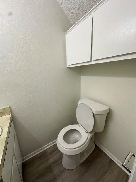 bathroom featuring baseboards, wood finished floors, and vanity