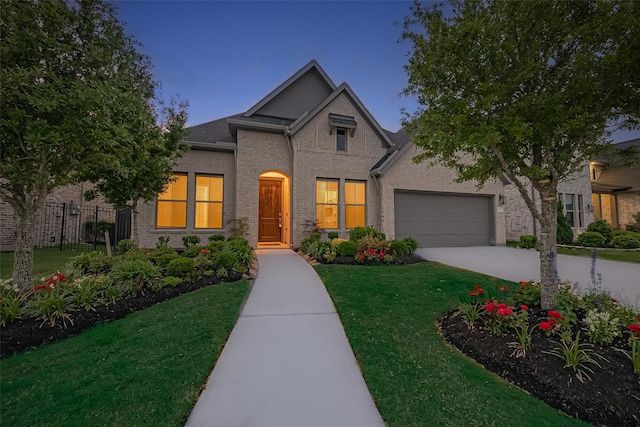 view of front of home with an attached garage, fence, driveway, and a front yard