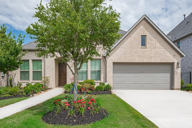 view of front of home with brick siding, an attached garage, driveway, and a front yard