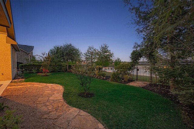 yard at dusk with a fenced backyard