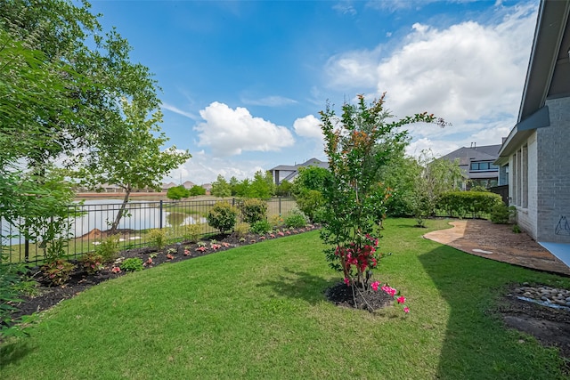 view of yard featuring a water view and fence