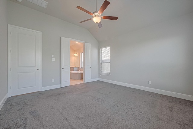 unfurnished bedroom featuring visible vents, vaulted ceiling, carpet floors, baseboards, and ensuite bath