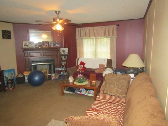 living room with a glass covered fireplace, a ceiling fan, and carpet flooring