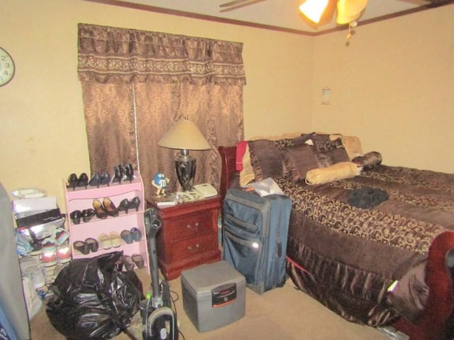 bedroom with crown molding, a ceiling fan, and carpet
