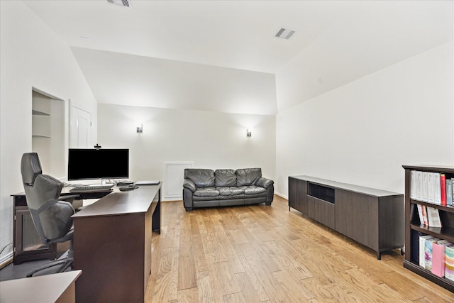 office featuring built in features, visible vents, light wood finished floors, and lofted ceiling