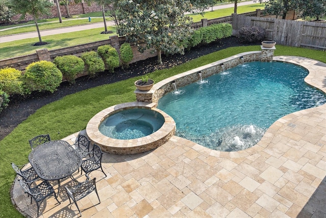 view of swimming pool with a fenced backyard, a yard, a patio area, and a pool with connected hot tub