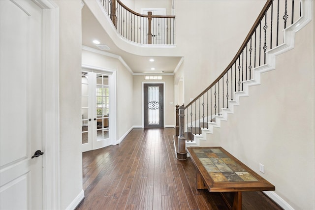 foyer entrance with crown molding, french doors, hardwood / wood-style floors, baseboards, and stairway
