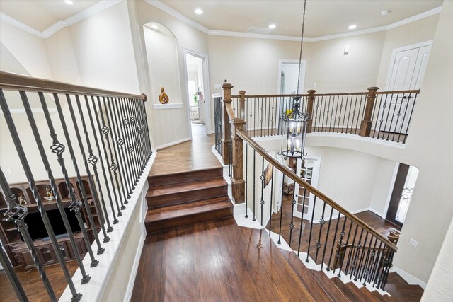 stairs with wood-type flooring, recessed lighting, baseboards, and crown molding