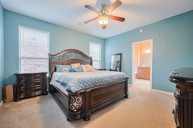 bedroom with baseboards, visible vents, light carpet, and ensuite bathroom