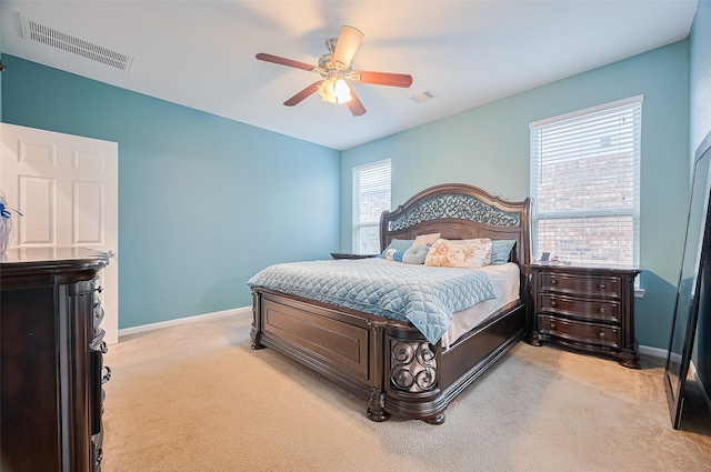 bedroom featuring light colored carpet, baseboards, visible vents, and a ceiling fan