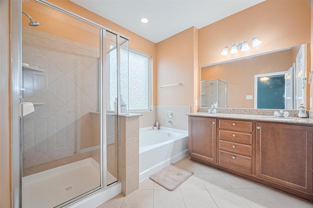bathroom featuring tile patterned flooring, a garden tub, double vanity, a sink, and a stall shower