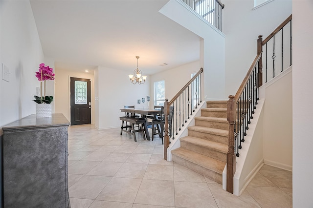 entryway with stairs, light tile patterned floors, an inviting chandelier, and a healthy amount of sunlight
