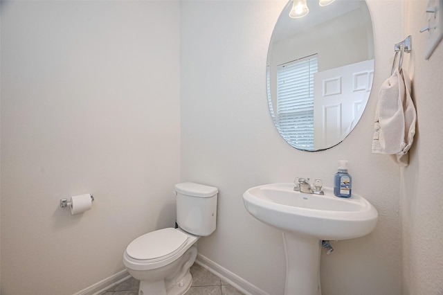 bathroom featuring toilet, baseboards, and tile patterned flooring