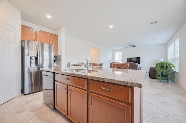 kitchen featuring stainless steel refrigerator with ice dispenser, a sink, dishwashing machine, and light tile patterned floors