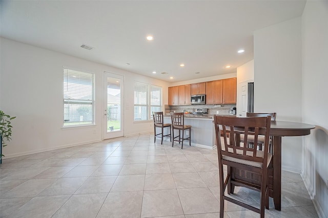 dining space featuring light tile patterned flooring, baseboards, visible vents, and recessed lighting