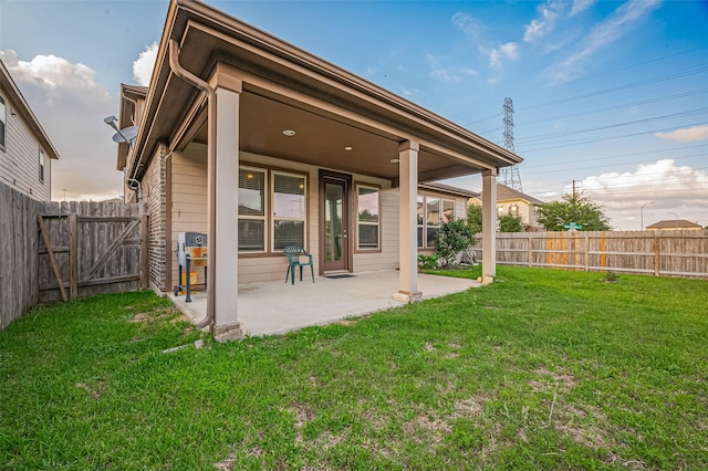 back of property featuring a fenced backyard, a gate, a patio, and a yard