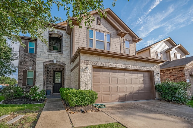 view of front facade with a garage, driveway, and stone siding