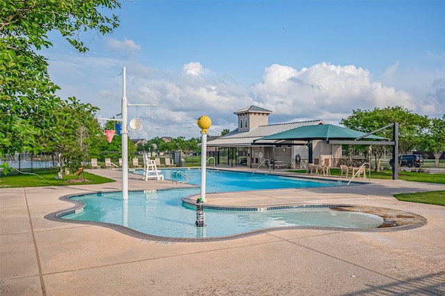 community pool with fence and a patio area