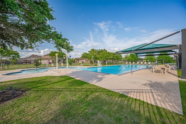 pool featuring a lawn, fence, and a patio
