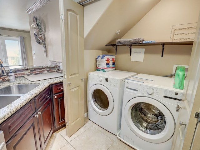 clothes washing area with a sink, light tile patterned flooring, and washer and clothes dryer