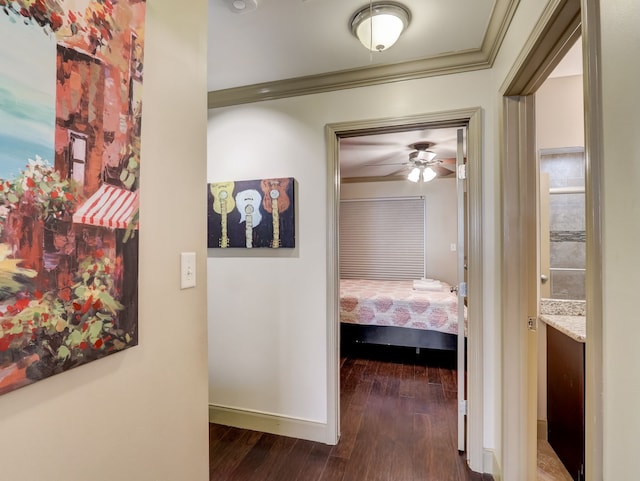 corridor with baseboards, ornamental molding, and hardwood / wood-style flooring