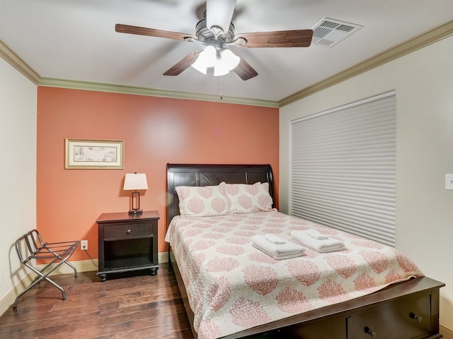 bedroom featuring crown molding, ceiling fan, baseboards, wood finished floors, and visible vents