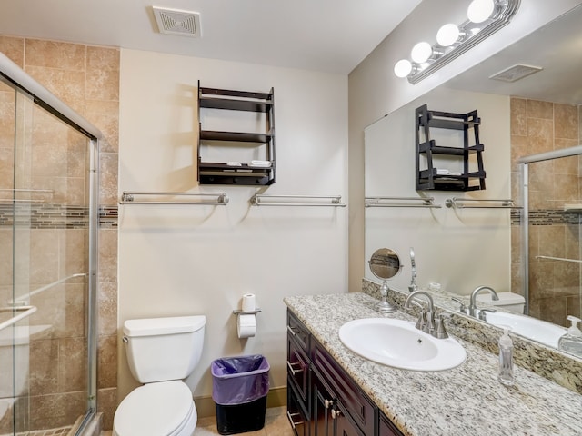 bathroom featuring vanity, toilet, visible vents, and a stall shower