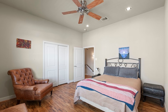 bedroom with recessed lighting, baseboards, wood finished floors, visible vents, and a closet