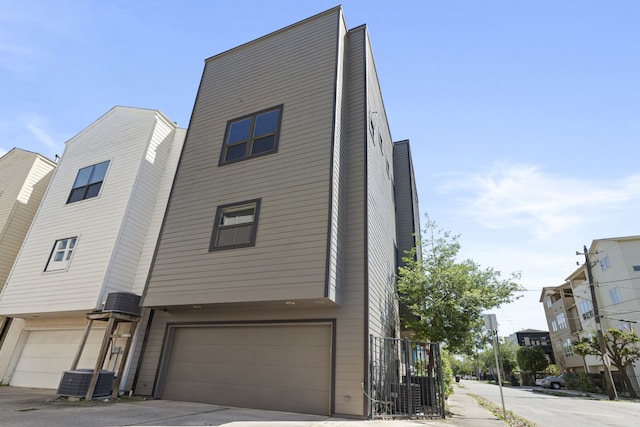 view of front facade with cooling unit and a garage