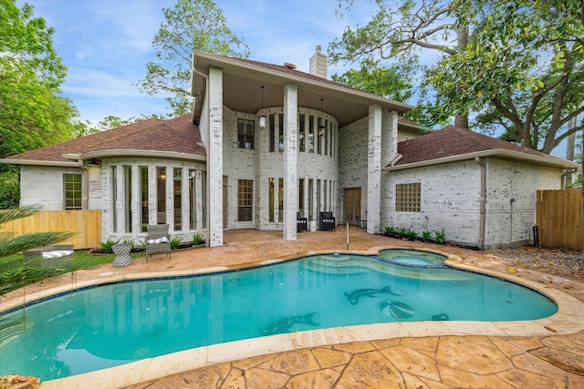 rear view of property with a patio area, roof with shingles, fence, and a chimney