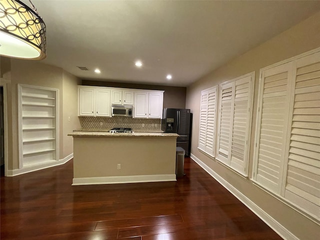 1718 Elgin St, Houston, TX 77004 - kitchen featuring stainless steel microwave, black fridge with ice dispenser, stove, dark wood finished floors, and white cabinetry