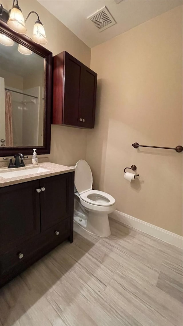 1718 Elgin St, Houston, TX 77004 - bathroom with baseboards, toilet, vanity, and wood finished floors