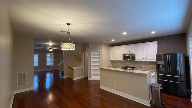 1718 Elgin St, Houston, TX 77004 - kitchen featuring black fridge with ice dispenser, stainless steel microwave, backsplash, dark wood-style flooring, and recessed lighting