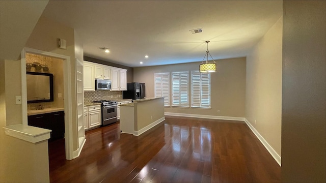 1718 Elgin St, Houston, TX 77004 - kitchen with stainless steel appliances, dark wood-type flooring, decorative backsplash, light countertops, and baseboards
